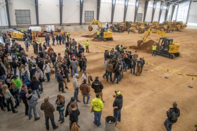 Gente mirando excavadoras mostradas por ingenieros