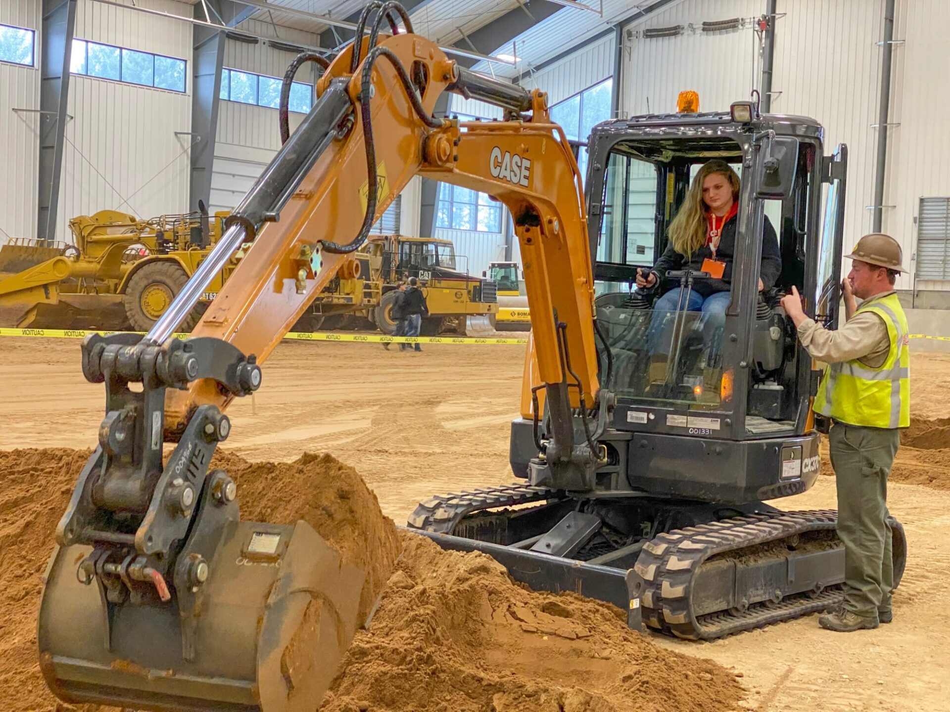 Chica en excavadora con ingeniero