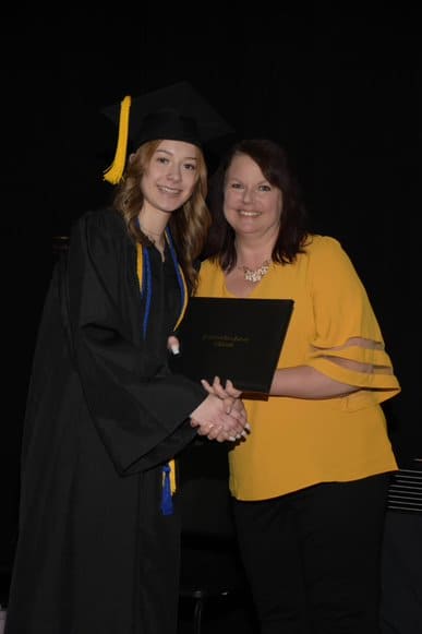Alumno y profesor en la ceremonia de graduación